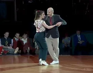 She grabs his hand to dance and the crowd goes wild with their swinging dance moves