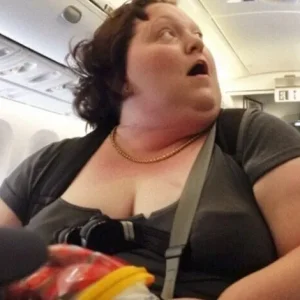 When the captain’s voice is heard speaking to the poor, heavy woman on the plane, the rich man mocks her. -A